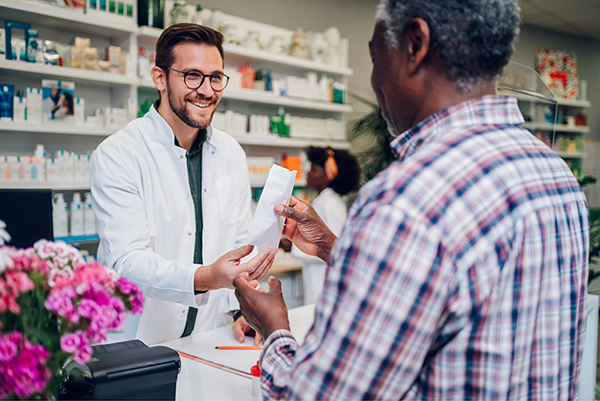 Pharmacist interacting with patient in community pharmacy setting